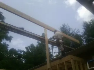 Carpenter setting a ridge beam over a new addition frame — Ice Dam Removal by Roofing Brothers in Forest Hill