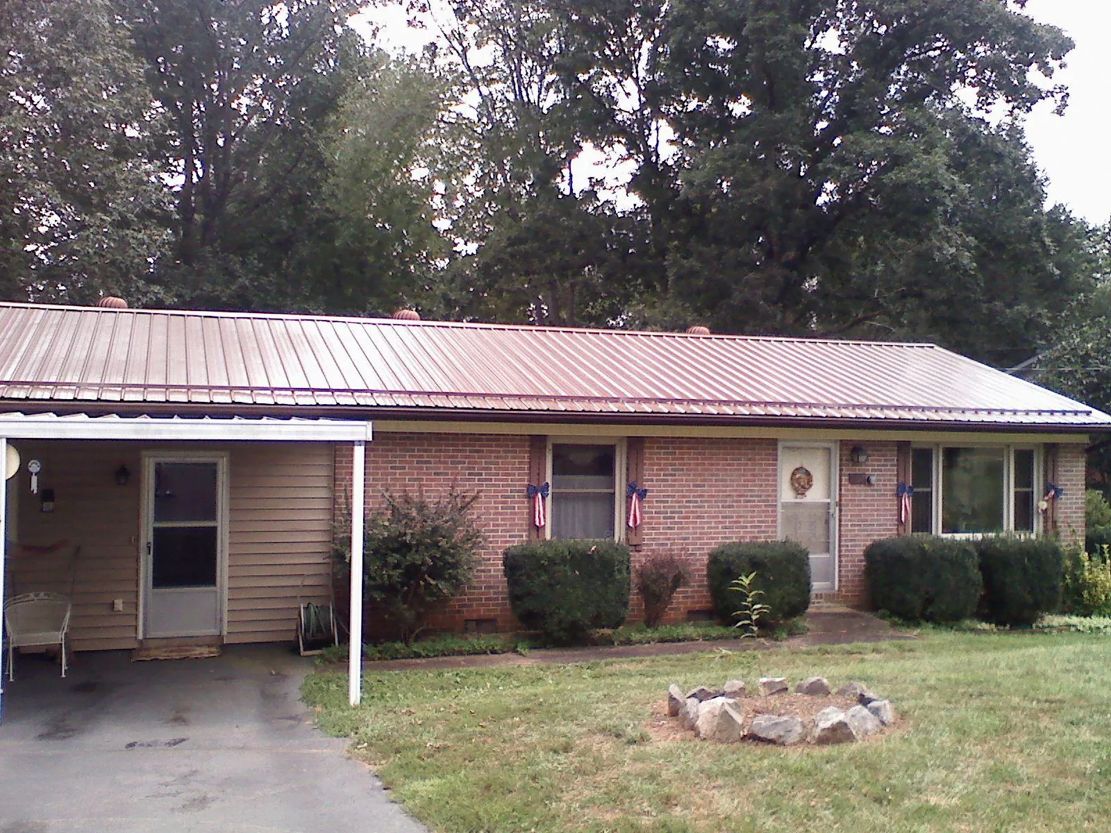 Bronze metal roof and carport on a brick ranch home — Roof Repair work by our crew in Forest Hill
